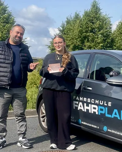 Fahrschülerin bzw. Fahrschüler der Fahrschule FAHRPLAN Frankfurt mit dem frisch bestandenen Führerschein