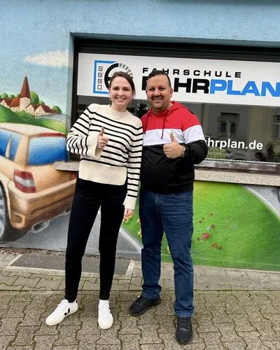 Fahrschülerin bzw. Fahrschüler der Fahrschule FAHRPLAN Frankfurt mit dem bestandenen Führerschein